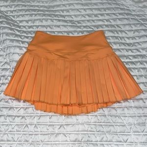 Gold hinge sunrise orange pleated tennis skirt